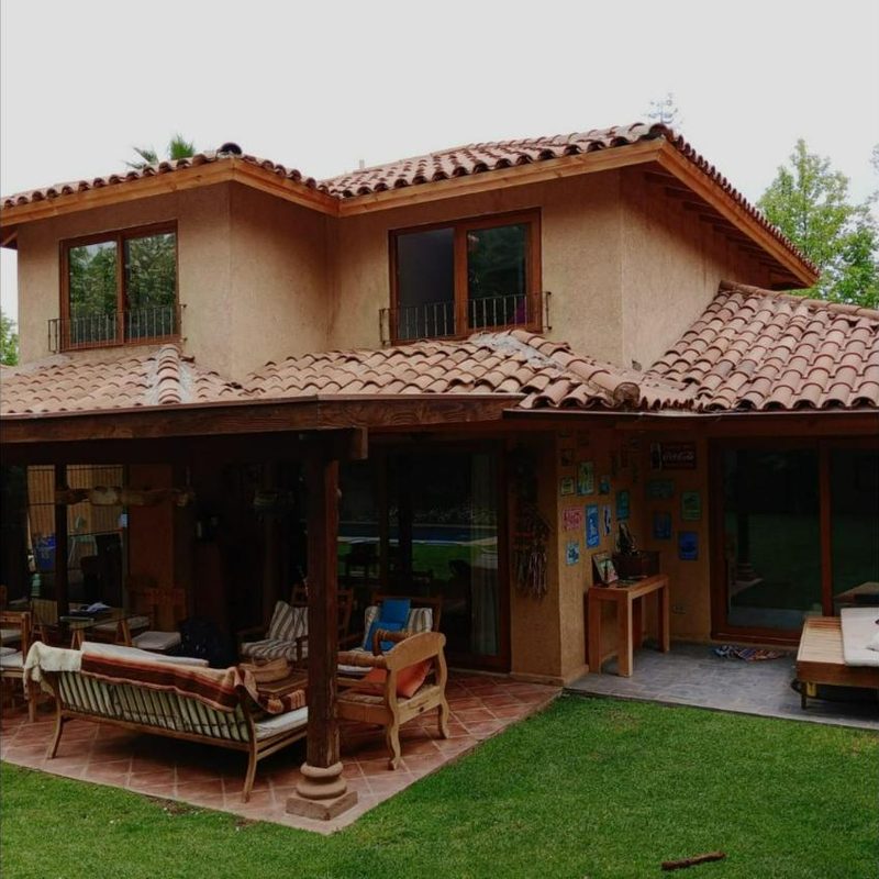 Casa de dos pisos con ventanas color roble en el segundo piso y techo de tejas
